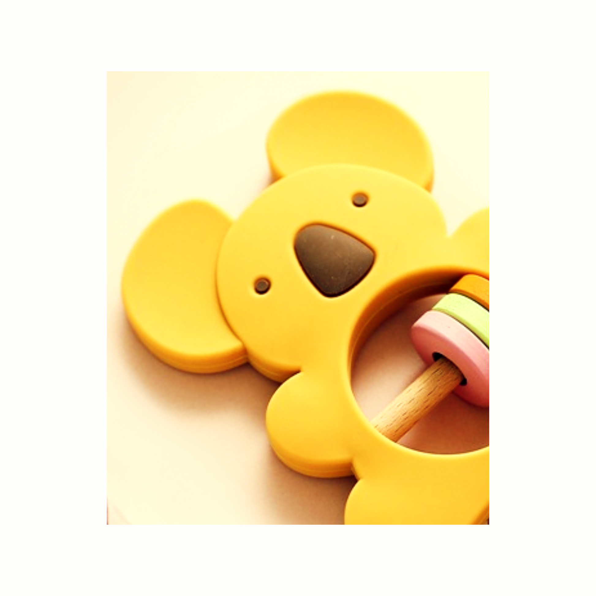 Close-up of gentle yellow silicone koala rattle teether for soothing baby gums