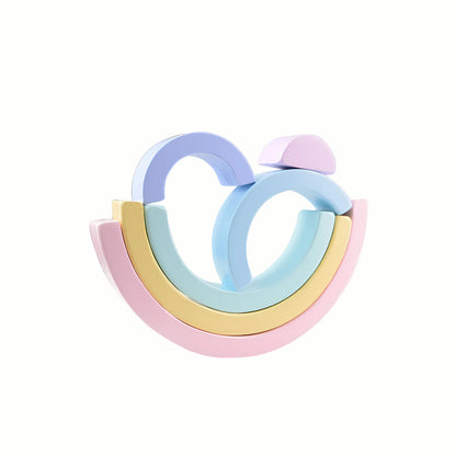 The Silicone Pastel Rainbow Stacking Blocks set out in arch and tunnel shapes, showing the range of sizes that help develop fine motor skills and spatial reasoning.