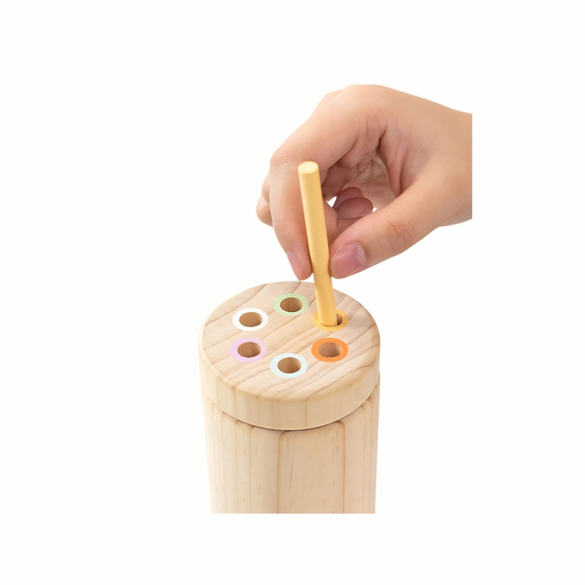 A  hand inserting a stick into the correct colored slot of the container from the Wooden Balance and Posting Sticks Game, developing color matching and fine motor skills.