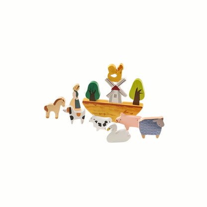 Wooden Farm Balance Game pieces scattered next to the crescent base, demonstrating the balancing challenge and open-ended stacking potential.