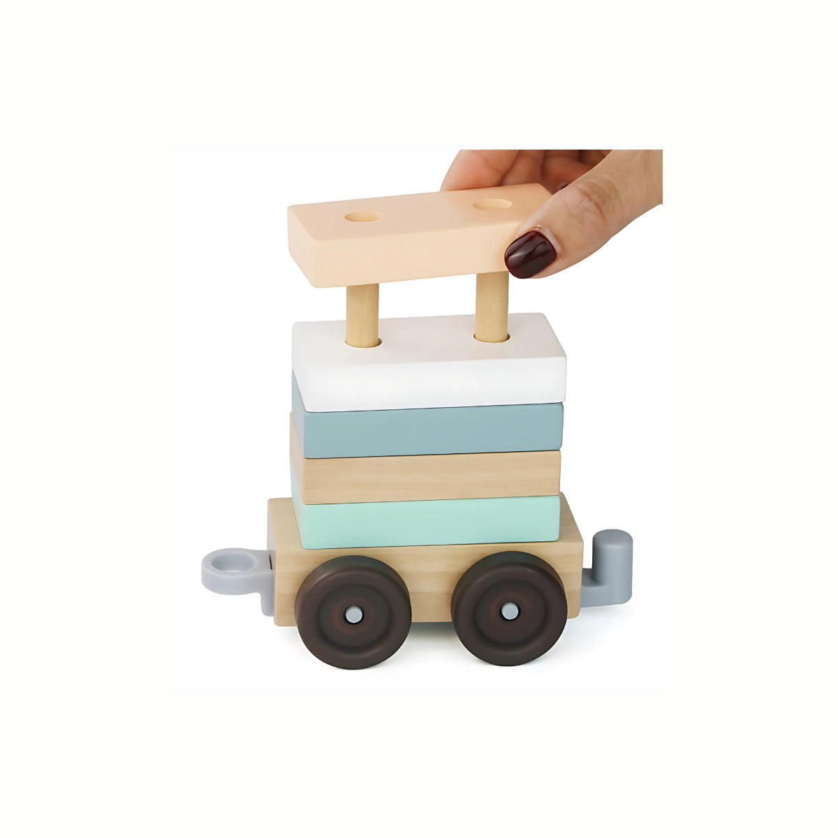 A  hand stacking a wooden block onto one of the train carriages of the Wooden Pull Along Stacking Train, developing fine motor skills and coordination.