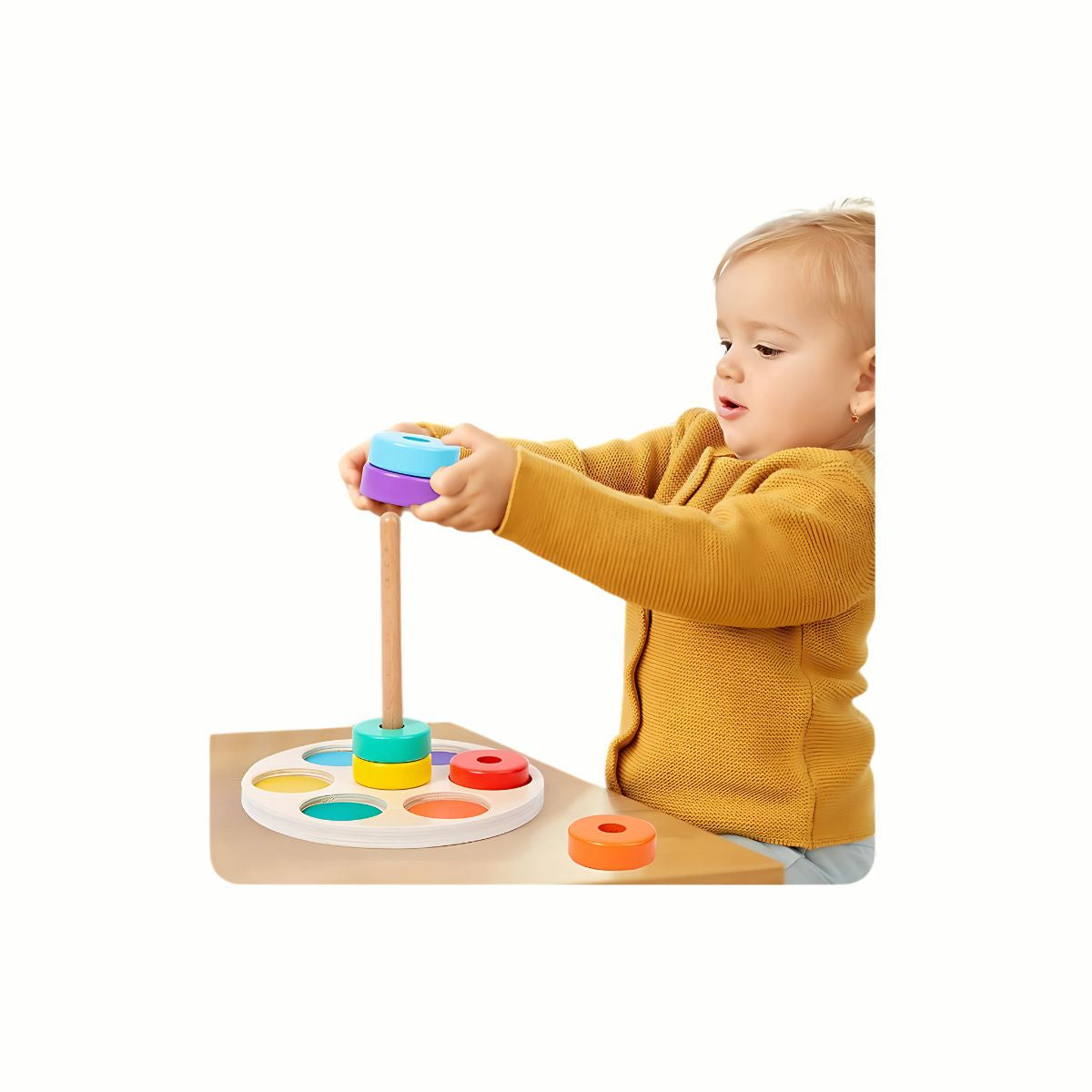 A child's hands placing a colorful ring onto the Wooden Rainbow Stacking & Sorting Rings Tower, developing fine motor skills and coordination.