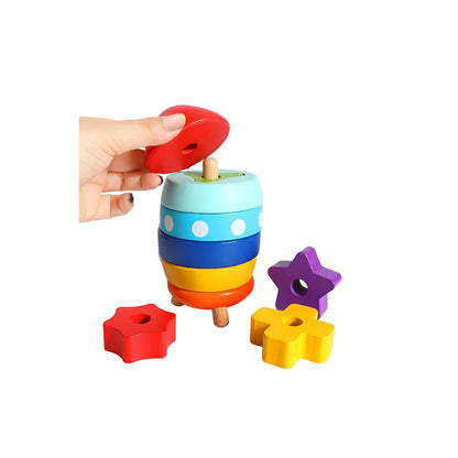 A child's hand placing a ring onto the partly stacked Wooden Rocket Stacking Rings, demonstrating the stacking action for fine motor skills.